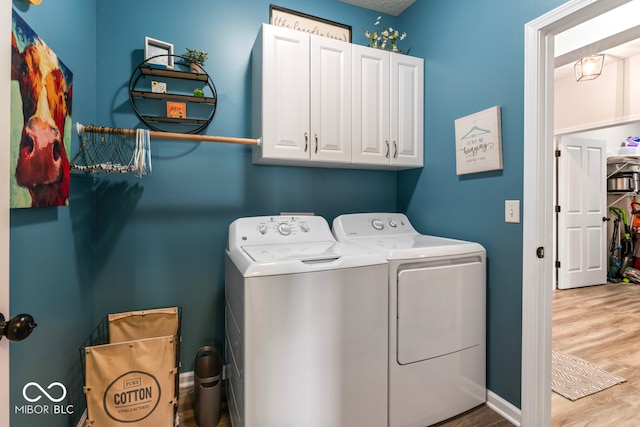 washroom featuring cabinets, washer and dryer, and hardwood / wood-style flooring