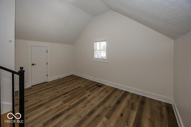 bonus room with lofted ceiling, a textured ceiling, and dark hardwood / wood-style flooring