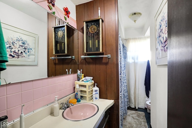 bathroom featuring vanity, toilet, and decorative backsplash