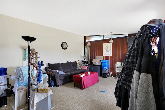 carpeted living room with wooden walls and lofted ceiling