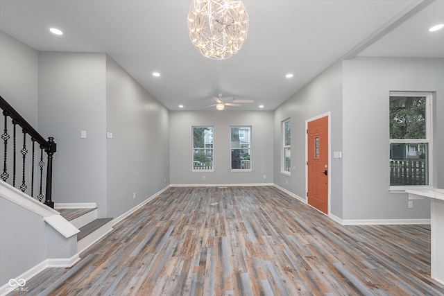 foyer entrance with wood-type flooring and ceiling fan with notable chandelier