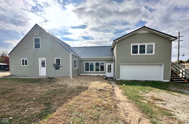 rear view of house featuring a yard and a garage