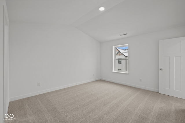 empty room featuring carpet and vaulted ceiling