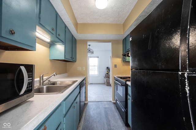 kitchen featuring hardwood / wood-style flooring, black appliances, blue cabinets, and sink