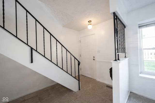 foyer entrance featuring a textured ceiling