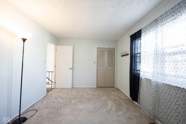 unfurnished bedroom with a textured ceiling and carpet flooring