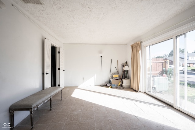 misc room with tile patterned floors and a textured ceiling