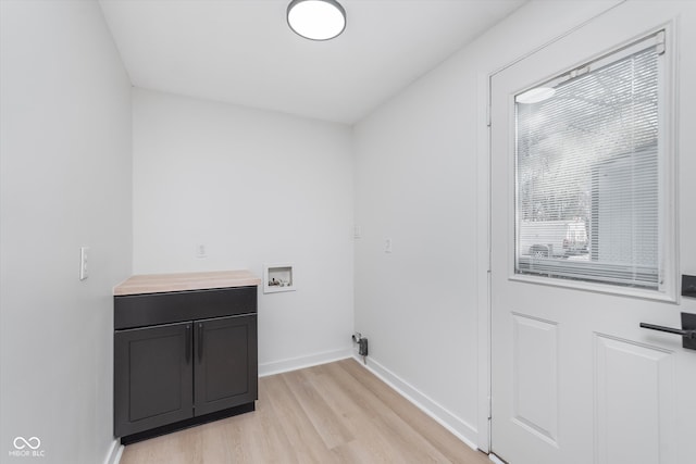 laundry area with washer hookup, cabinets, and light hardwood / wood-style flooring