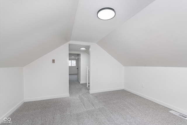 bonus room with carpet flooring and vaulted ceiling