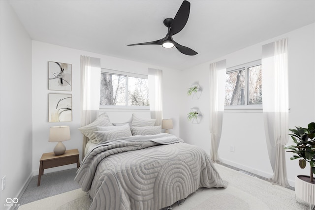 carpeted bedroom with multiple windows and ceiling fan