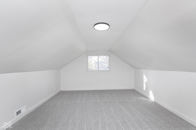 additional living space featuring lofted ceiling and carpet floors