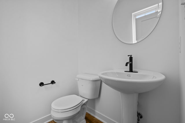 bathroom with hardwood / wood-style floors and toilet