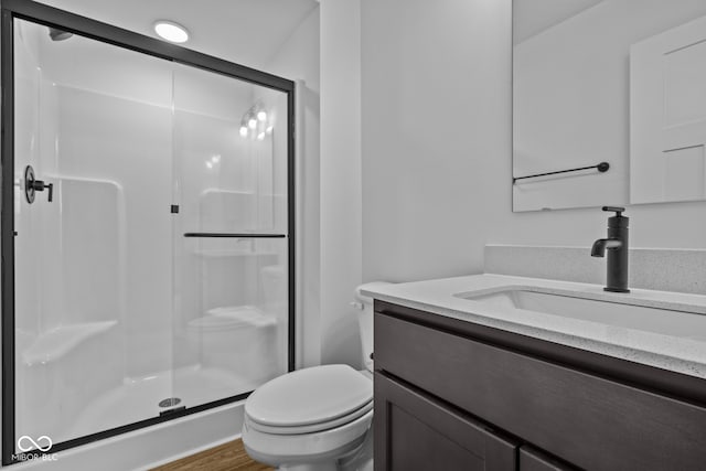 bathroom with vanity, hardwood / wood-style flooring, toilet, and an enclosed shower