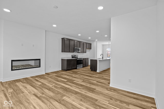 unfurnished living room featuring light hardwood / wood-style floors and sink