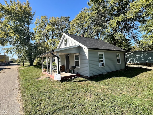 view of property exterior featuring covered porch and a lawn