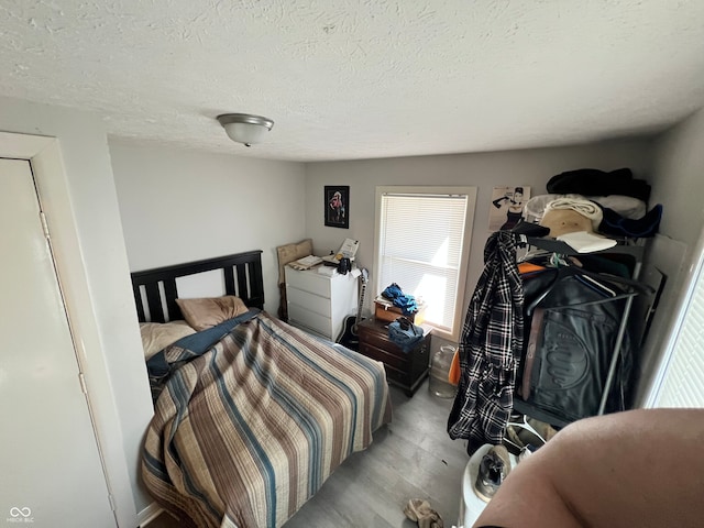 bedroom featuring a textured ceiling and light wood-type flooring