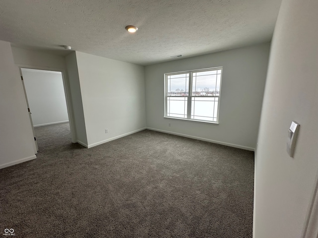 carpeted empty room with a textured ceiling