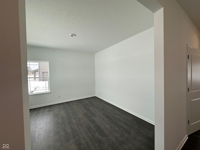 unfurnished room featuring dark hardwood / wood-style floors and a textured ceiling