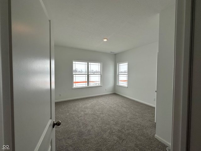 carpeted spare room with a textured ceiling