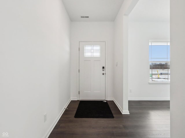 foyer with a healthy amount of sunlight, visible vents, dark wood finished floors, and baseboards