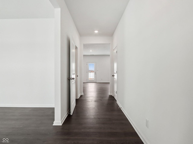 hall with baseboards, dark wood-type flooring, and recessed lighting