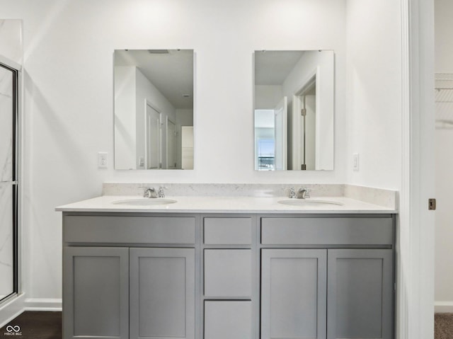 full bathroom with double vanity, a spacious closet, and a sink