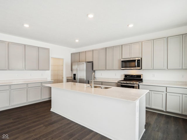 kitchen with a center island with sink, dark wood-type flooring, stainless steel appliances, gray cabinetry, and recessed lighting