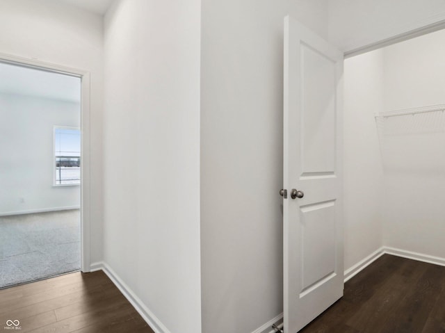 corridor featuring dark wood-style floors and baseboards