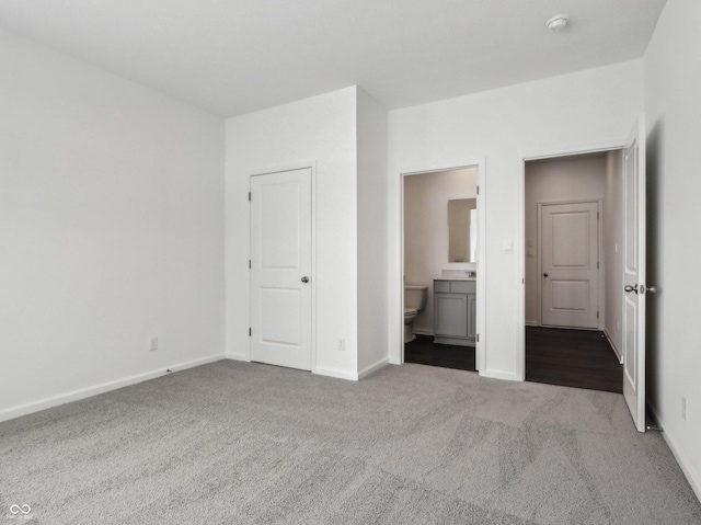 unfurnished bedroom with light carpet, connected bathroom, and baseboards