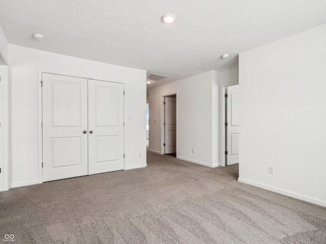 unfurnished bedroom featuring a closet, light carpet, and baseboards