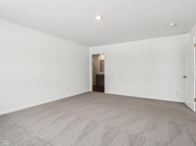 carpeted empty room with baseboards