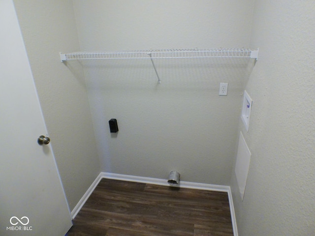 clothes washing area featuring dark hardwood / wood-style floors