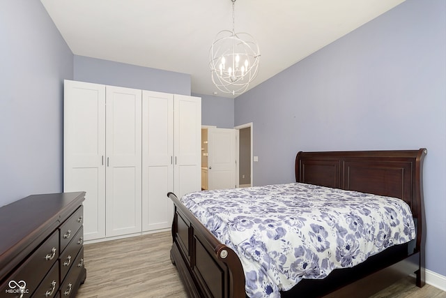 bedroom with a chandelier and light wood-type flooring