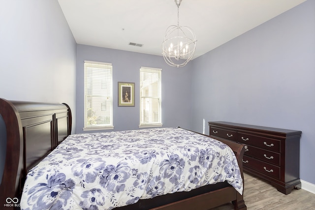 bedroom featuring light hardwood / wood-style floors and an inviting chandelier