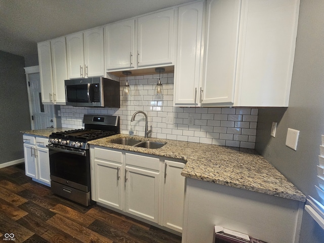 kitchen with appliances with stainless steel finishes, sink, dark hardwood / wood-style flooring, and white cabinetry