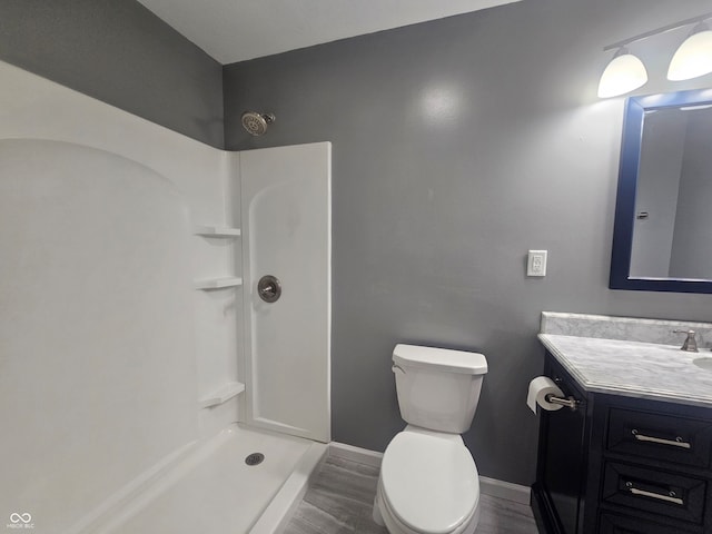 bathroom featuring a shower, wood-type flooring, vanity, and toilet