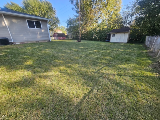 view of yard with central AC and a shed