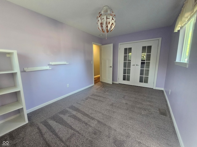 unfurnished room with french doors and dark colored carpet