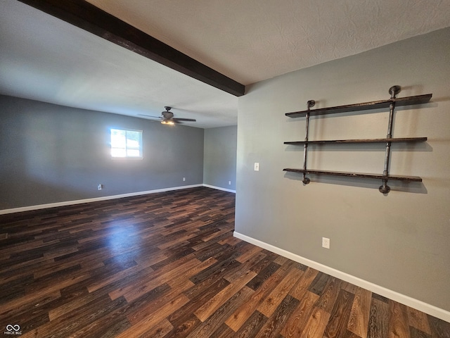 empty room with beam ceiling, dark hardwood / wood-style flooring, a textured ceiling, and ceiling fan