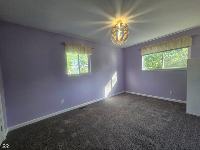 unfurnished room with dark colored carpet