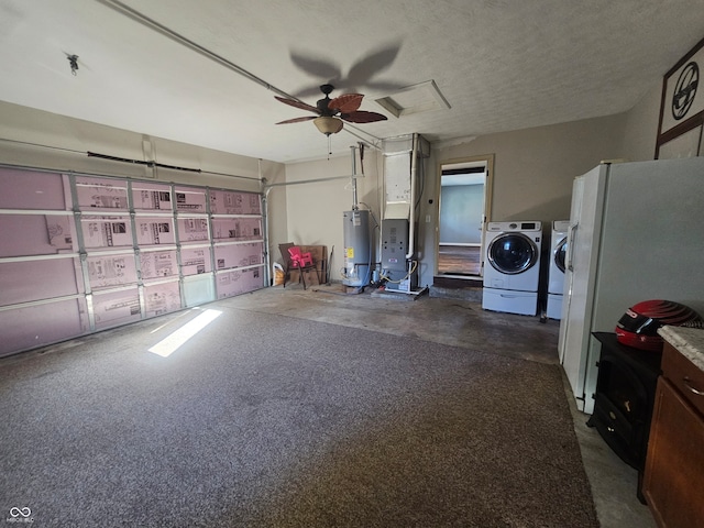 garage featuring gas water heater, white refrigerator, washer and dryer, and ceiling fan