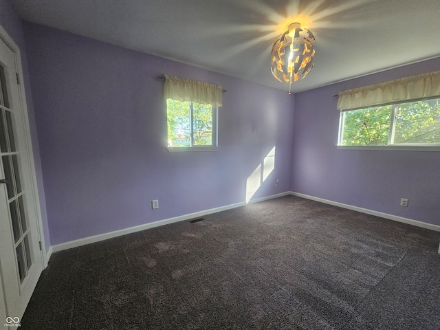 carpeted spare room featuring plenty of natural light