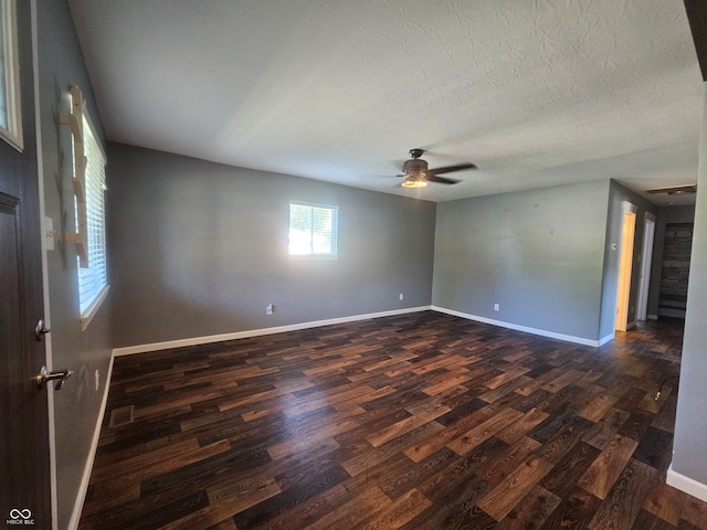 spare room with ceiling fan, a textured ceiling, and dark hardwood / wood-style flooring