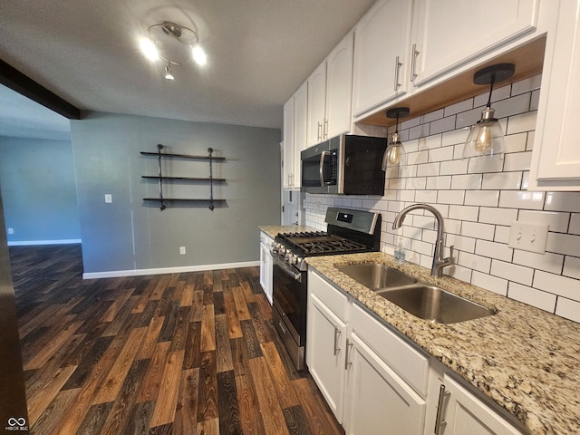 kitchen featuring sink, dark wood-type flooring, white cabinetry, appliances with stainless steel finishes, and light stone countertops