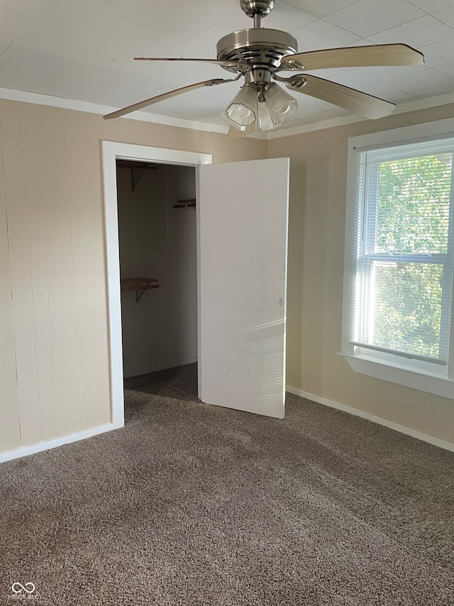 unfurnished bedroom with carpet floors, a closet, crown molding, and ceiling fan