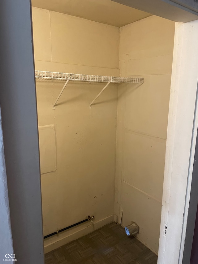 laundry area featuring dark parquet flooring