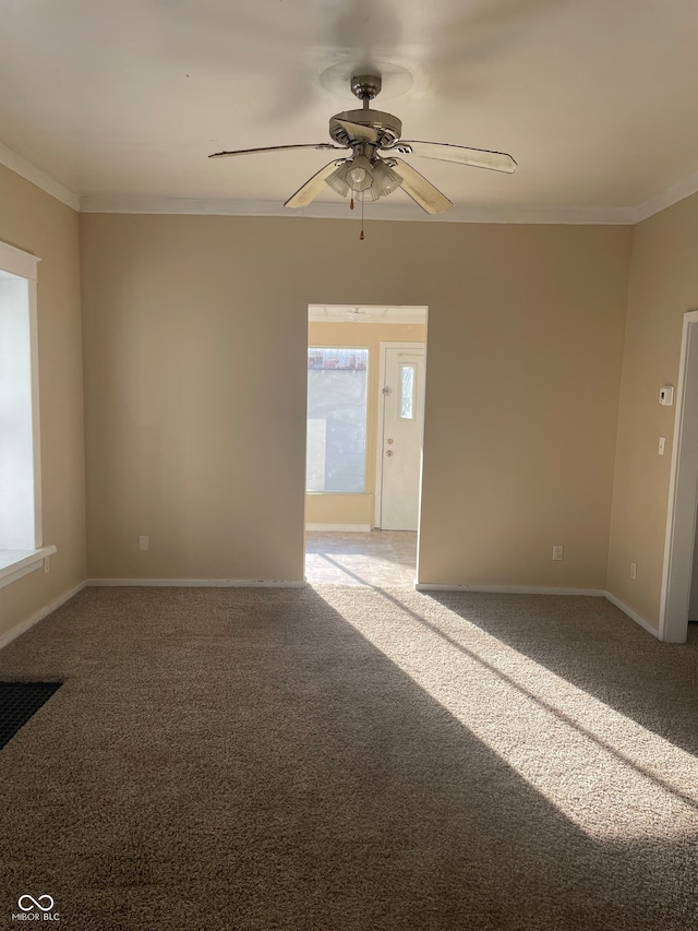 unfurnished room with ceiling fan, light carpet, and ornamental molding