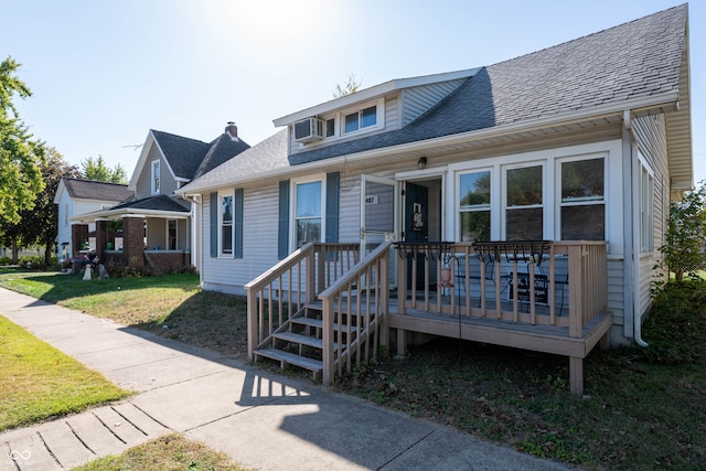 view of front of home with a deck and a front yard