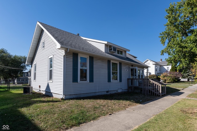 view of property exterior with central AC and a lawn