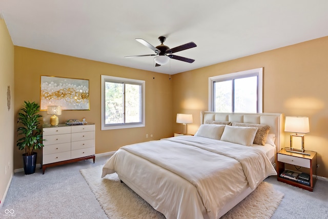 carpeted bedroom with ceiling fan and multiple windows